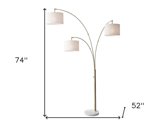 74" Brass Three Light Arc Floor Lamp With Off White Fabric Drum Shade