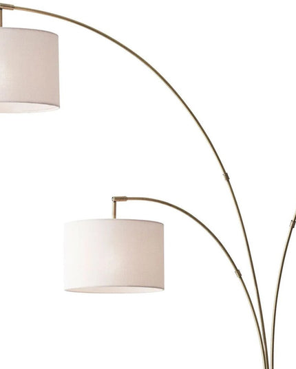 74" Brass Three Light Arc Floor Lamp With Off White Fabric Drum Shade