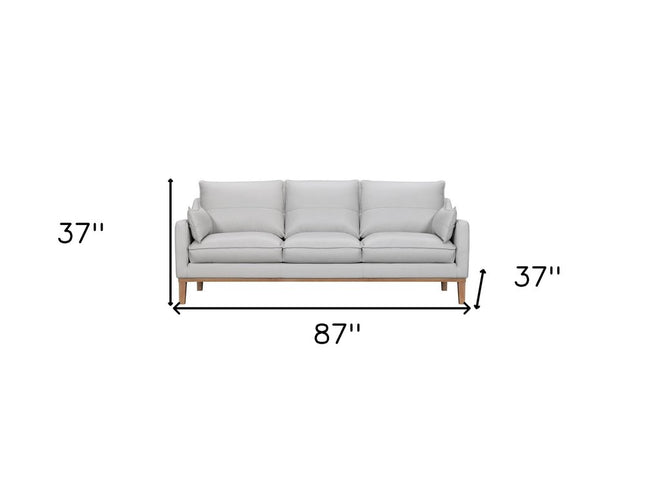 87" Gray Leather Sofa And Toss Pillows With Brown Legs