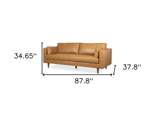 88" Tan Leather Sofa And Toss Pillows With Brown Legs